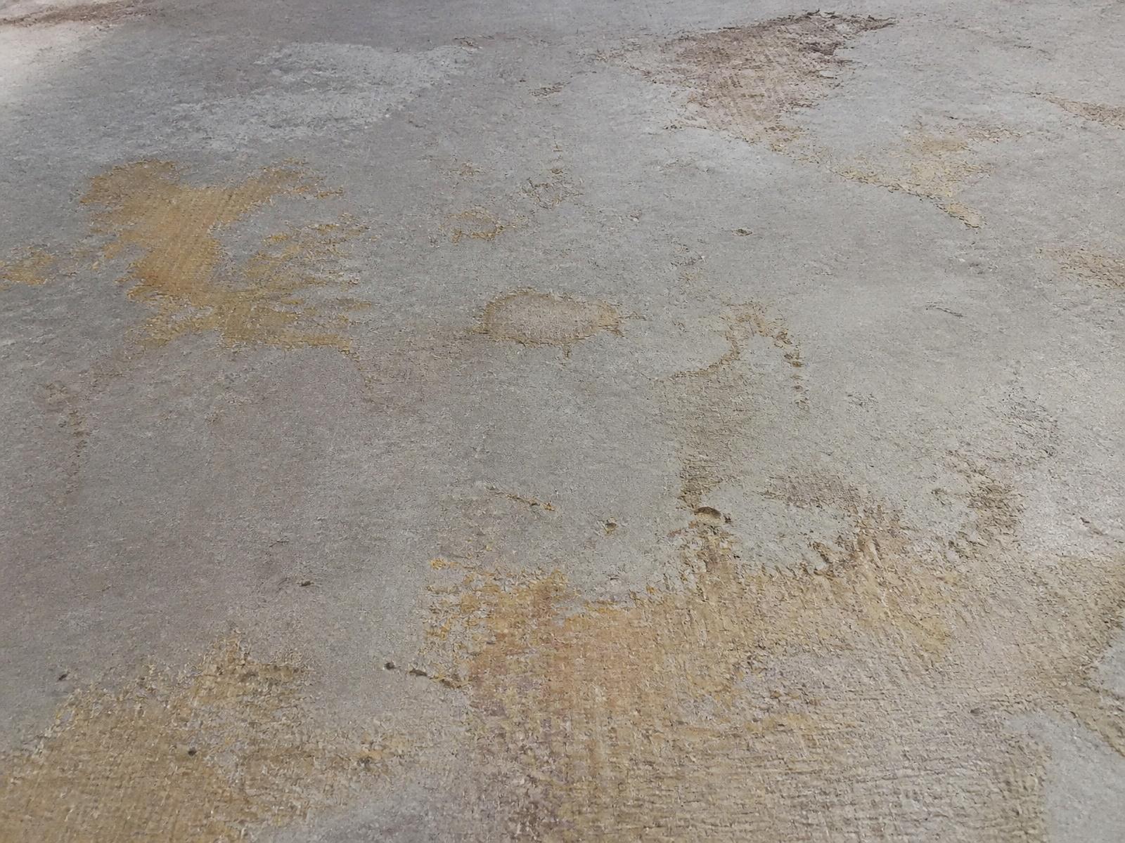 Interior concrete floor with glue residue after floor coverings were removed