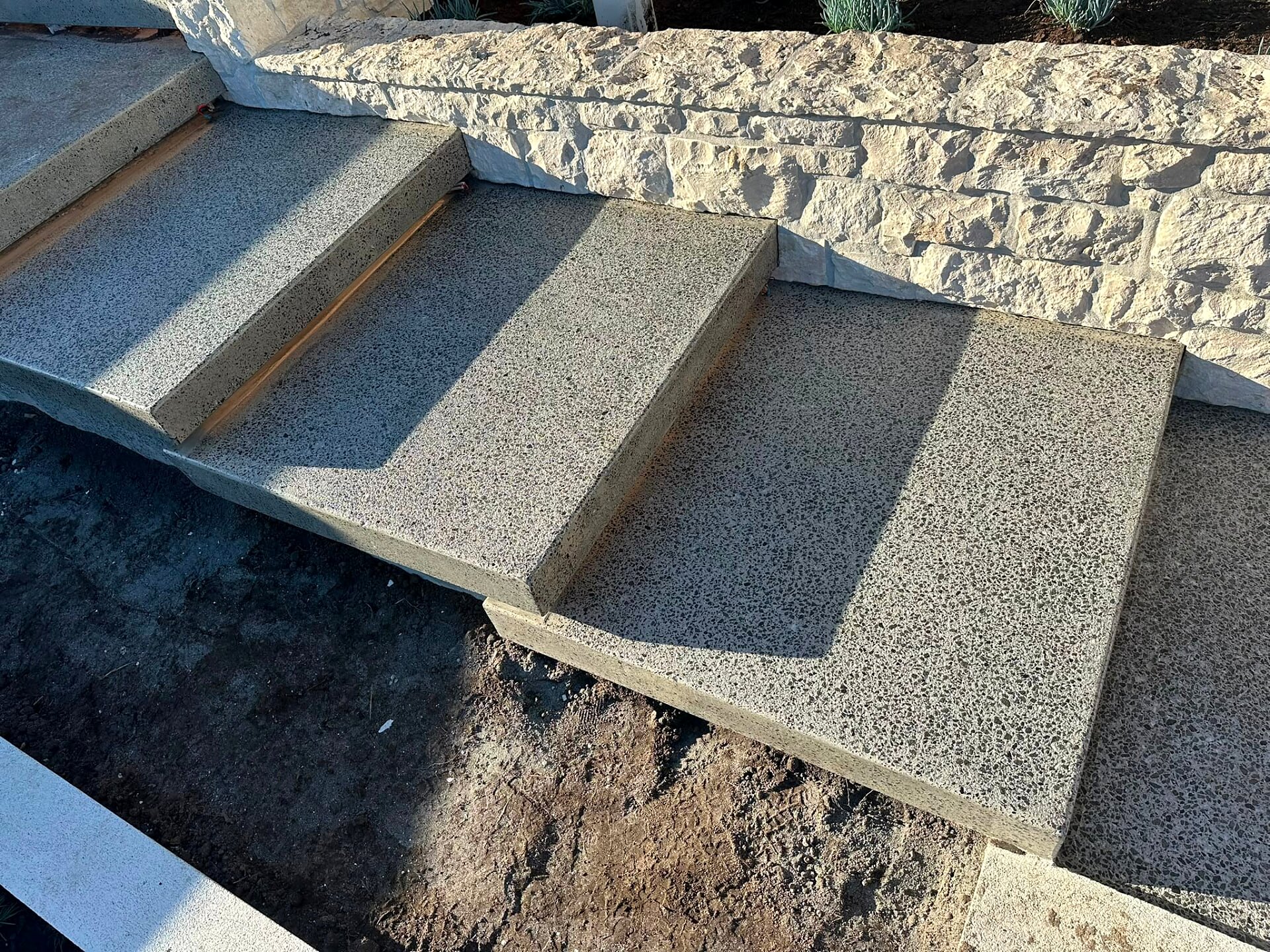 Exposed aggregate concrete steps in an exterior landscape
