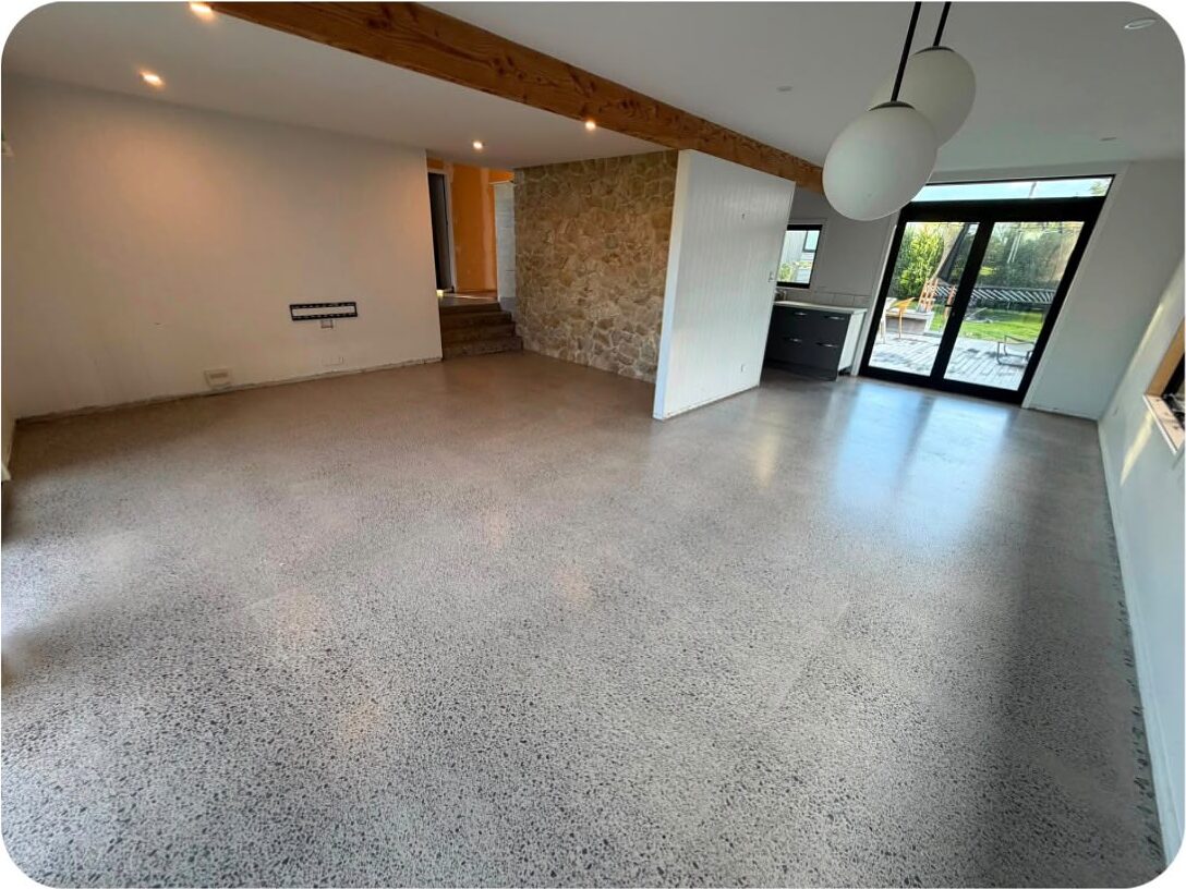 Light exposure polished concrete floor in a living area, fine grey stone showing evenly across the slab