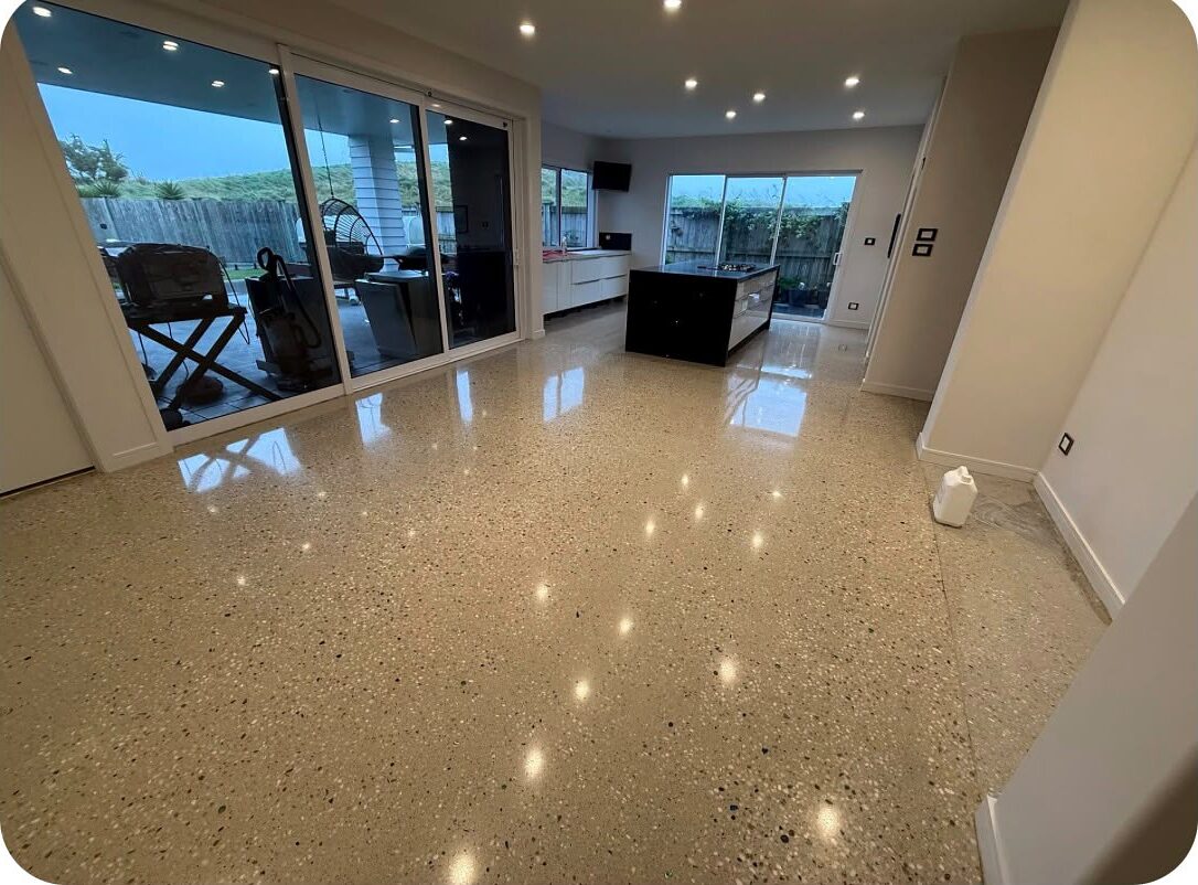 Medium exposure polished concrete floor in a kitchen and living area, cream cement with stone fully cut