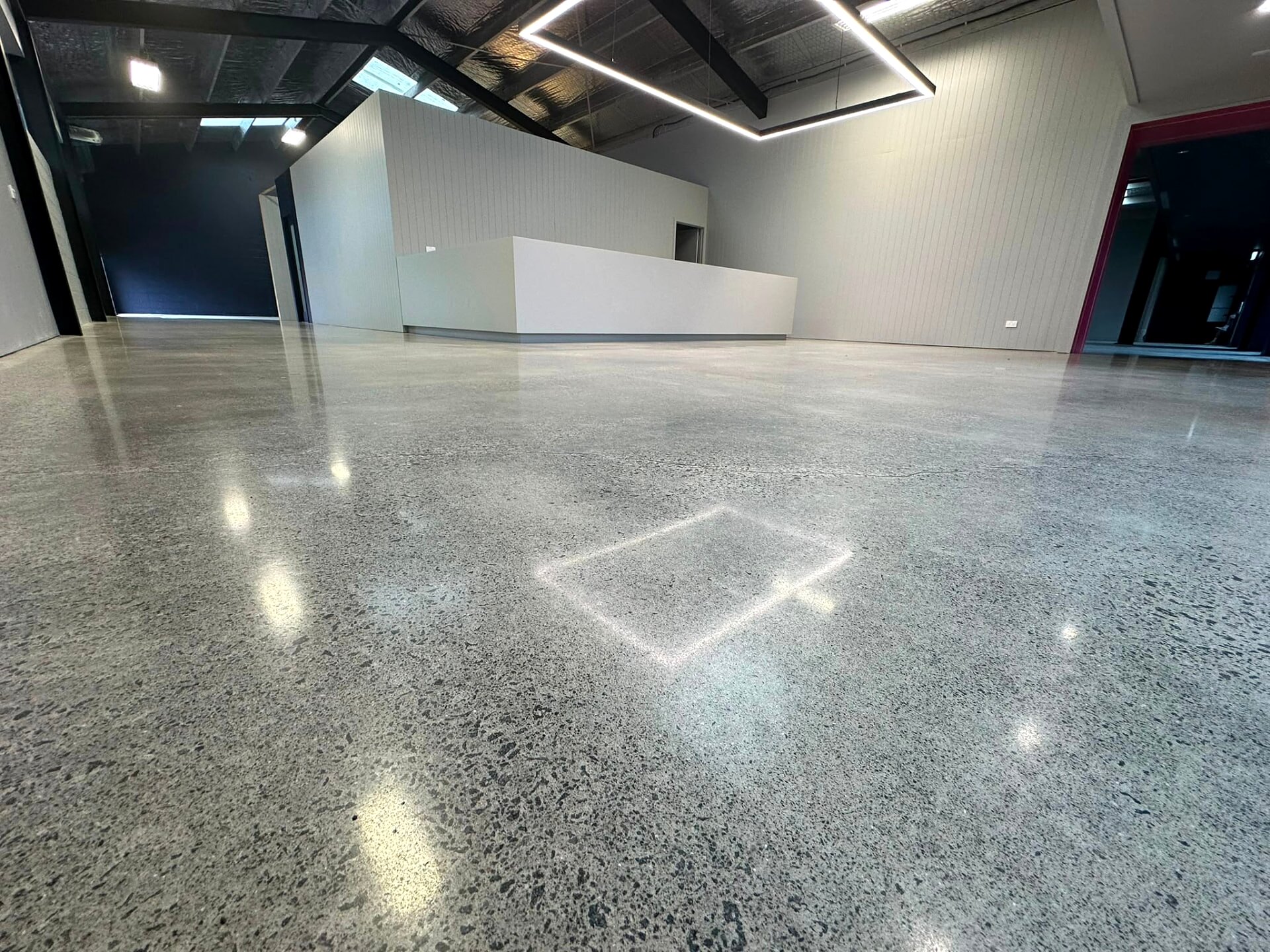 Ground concrete floor running the length of a bare commercial interior