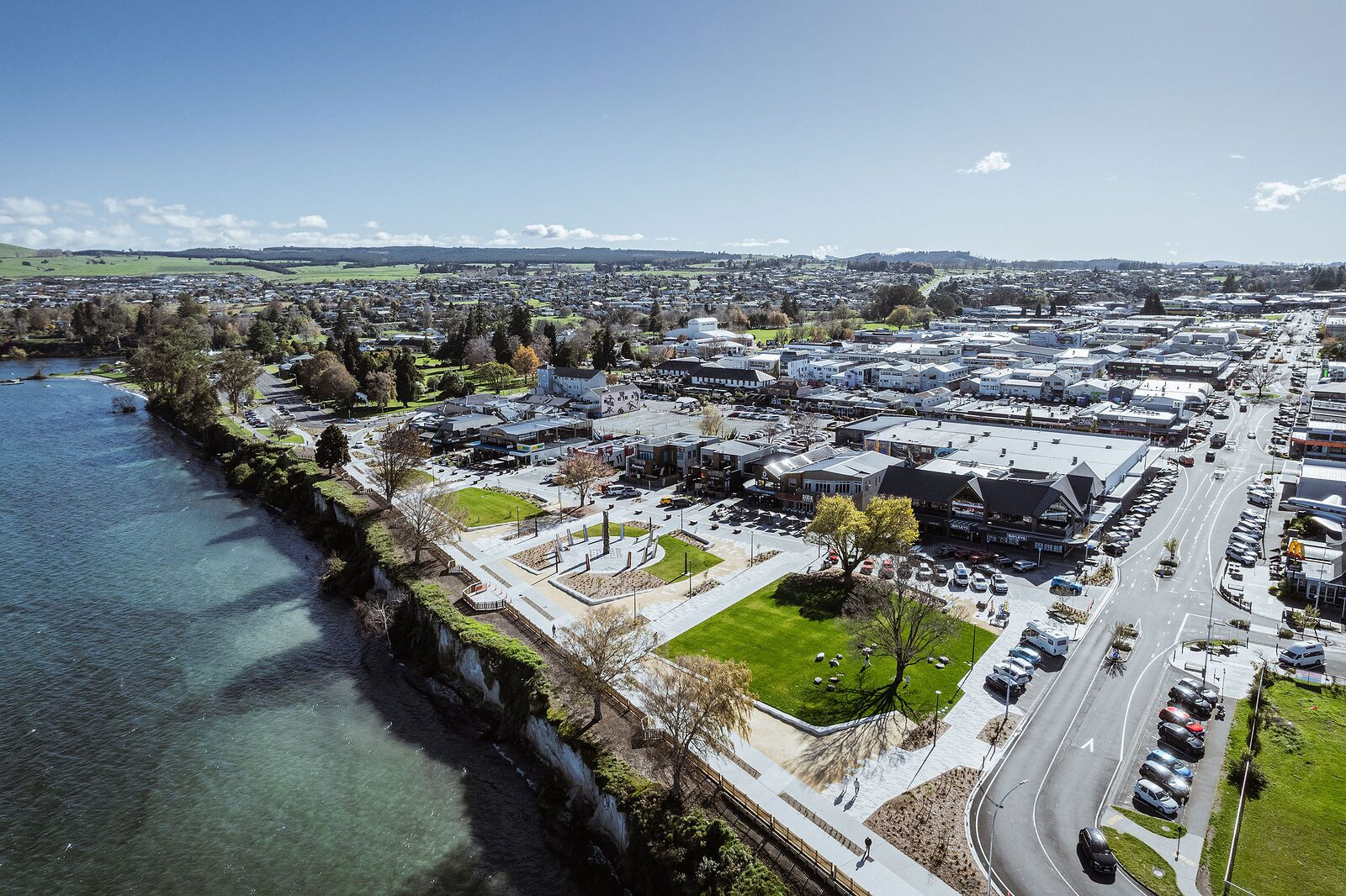 Wide exterior view of textured concrete steps and plaza meeting the lake edge
